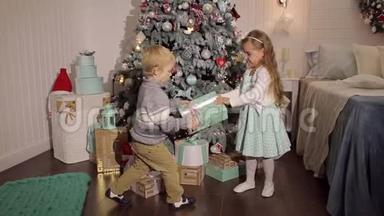 两个<strong>小朋友</strong>在圣诞树附近打开礼物。